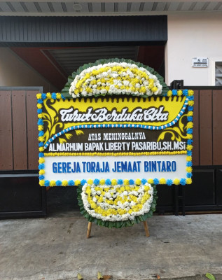 Papan Bunga Duka di Pangkul